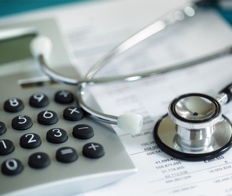 Image of Stethoscope on top of financial papers and calculator