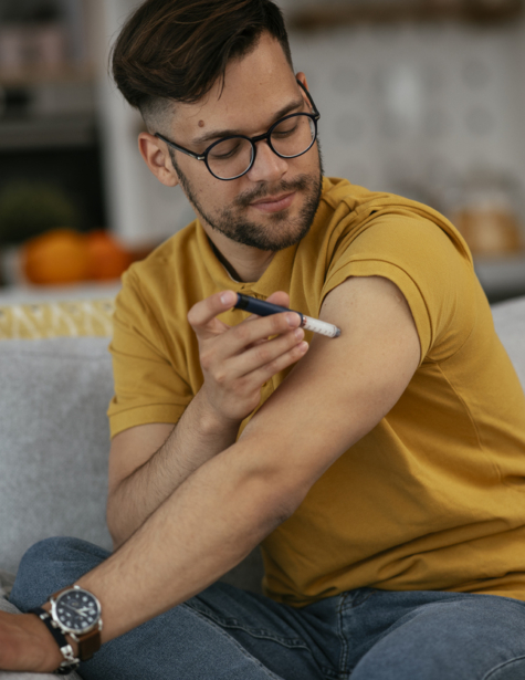 Photo of a man giving himself an insulin shot at home