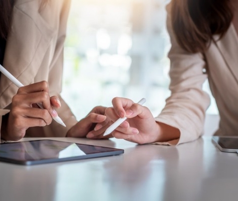 Image of two people discussing over a tablet